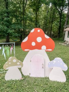 a group of mushrooms sitting on top of a lush green field next to a forest