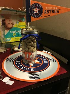 a glass jar filled with nuts sitting on top of a table next to a sign