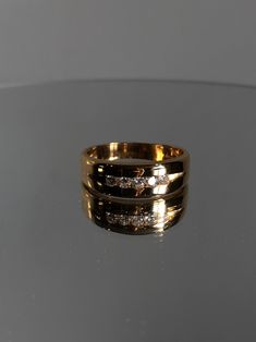 a gold ring with three diamonds sitting on top of a table