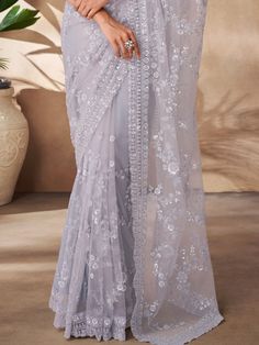 This exquisite ensemble is perfect for celebrating special occasions like parties, receptions, and more. The grey color net saree features intricate threadwork, sequin work, and zarkan work, adding a touch of elegance to your look. Paired with a matching net blouse embellished with the same detailing, this saree set is sure to make you stand out from the crowd.
This saree set includes a 5.50-meter saree length for a graceful drape, along with unstitched blouse material for a customizable fit. Th Festive Silver Pre-draped Saree With Resham Embroidery, Silver Saree For Diwali Reception, Silver Saree For Reception And Diwali, Festive Silver Saree For Reception, Gray Saree With Zari Work For Wedding, Elegant Saree With Intricate Embroidery For Celebration, Gray Saree With Dupatta For Wedding, Festive Gray Dupatta With Resham Embroidery, Net Pre-draped Saree For Party And Festivals