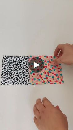 someone is cutting out an animal print paper piece with scissors and glue on the edge