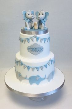 a blue and white cake with two elephants on top