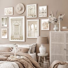 a bedroom with many pictures on the wall above it and a bed covered in blankets