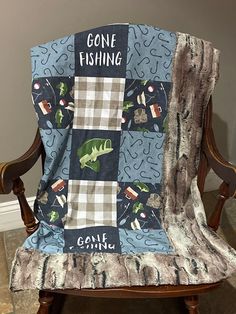 a chair with a blanket on it that says gone fishing