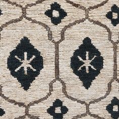 an area rug with black and white designs on the front, along with a beige background