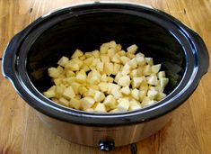 chopped potatoes in a slow cooker on a wooden table