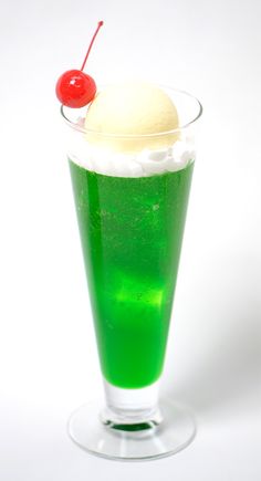 a green drink with ice cream and a cherry on top