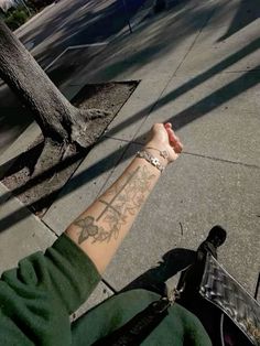 a person with a tattoo on their arm is holding onto a bike handlebars