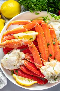 crab legs on a plate with lemons and parsley