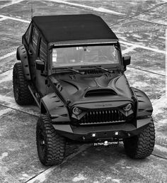 a black jeep is parked on the concrete