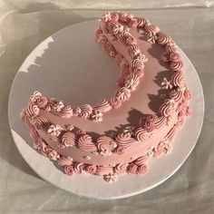 there is a pink cake on the plate and it looks like swirls are in the air