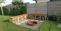 a fire pit in the middle of a yard with logs stacked on top of it