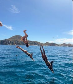 two people diving into the ocean from a boat