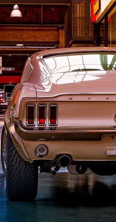 the rear end of an old car parked in a garage