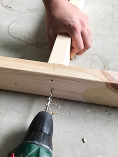 a person using a power drill to attach a piece of wood