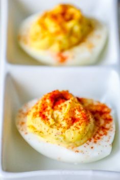 three deviled eggs on a white tray