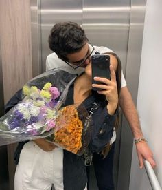 a man taking a selfie while holding flowers