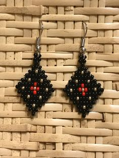 black and red beaded earrings with silver beads on a woven wicker basket background