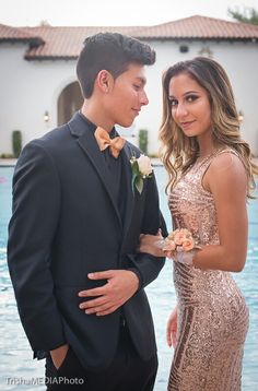 a man in a tuxedo standing next to a woman wearing a sequin dress