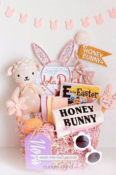 a pink basket filled with lots of cute items next to a bunnies bunnies sign