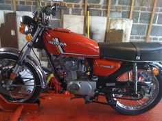 an orange and black motorcycle parked in a garage