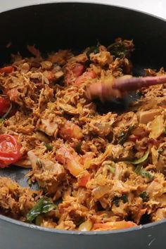 a pan filled with meat and vegetables on top of a stove