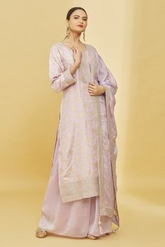 Pink straight fit kurta with all-over zari woven floral motifs and gold thread and sequin embroidery on the placket, cuffs and hem. Comes with georgette palazzo and a border embroidered dupatta.
Components: 3
Pattern: Embroidery
Type Of Work: Zari, Thread and Sequin
Neckline: Notch
Sleeve Type: Long
Fabric: Kurta: Silk and Palazzo and Dupatta: Georgette; Lining: Butter Crepe
Color: Pink
Other Details: 
Kurta with slits on the side
Dupatta with embroidered border and tassels on the ends
Closure: Festive Unstitched Suit With Gold Embroidery For Eid, Festive Gold Embroidery Unstitched Suit For Eid, Eid Festive Unstitched Suit With Gold Embroidery, Festive Gold Embroidered Straight Kurta Salwar Kameez, Eid Chanderi Salwar Kameez With Gold Embroidery, Unstitched Traditional Wear With Gold Embroidery For Eid, Festive Chanderi Sets With Gold Embroidery, Unstitched Suit With Gold Embroidery For Festive Occasions, Diwali Gold Embroidery Straight Kurta Salwar Kameez