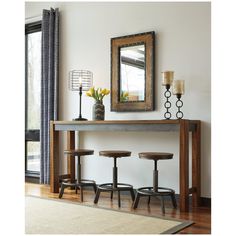 a table with three stools and a mirror on the wall above it in a living room