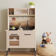 a toy kitchen with toys on the counter and shelves above it, in a child's playroom