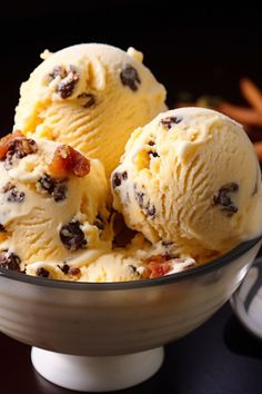 three scoops of ice cream in a bowl with chocolate chips and bacon on top