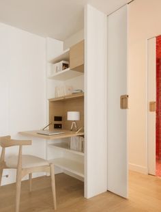 an open door leading to a desk and chair in a room with wood flooring