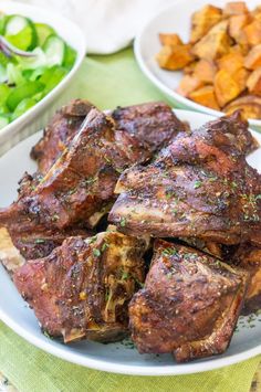 some meat is on a white plate near other plates of vegetables and salads in bowls