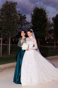 two women in wedding gowns standing next to each other