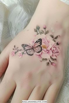 a woman's hand with pink flowers and butterflies on it