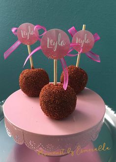 three chocolate covered strawberries on top of a pink cake plate with nameplates