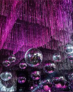 disco balls hanging from the ceiling in front of purple lights