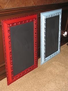 two framed chalkboards sitting next to each other on the floor