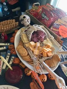 a table topped with lots of halloween food and treats on it's sides, including crackers