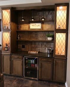 a kitchen with wood cabinets and tile flooring, lights on above the counter top