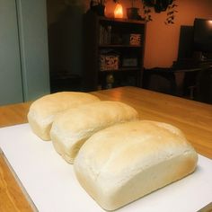 two loaves of bread sitting on top of a cutting board in front of a tv