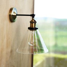 a light that is on the side of a wooden wall next to a glass window