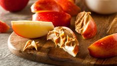 apples and peanut butter on a cutting board