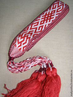 two red tassels with white and red designs on them sitting next to each other