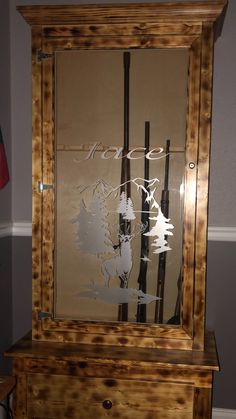 a wooden cabinet with etched glass on the front and bottom, sitting in a room next to a flag