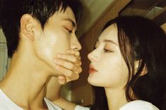 a man and woman kissing each other in front of a mirror with their eyes closed