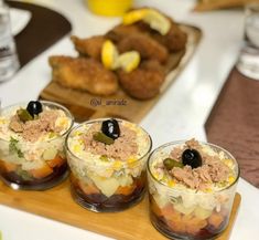 three small cups filled with food sitting on top of a table