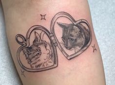 a cat and a dog in a heart shaped frame tattoo on the leg