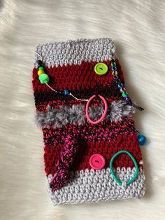 a crocheted purse with buttons and beads on it sitting on a white surface