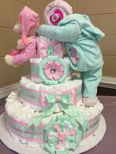 a baby shower cake with teddy bears on top and diapers all over the bottom