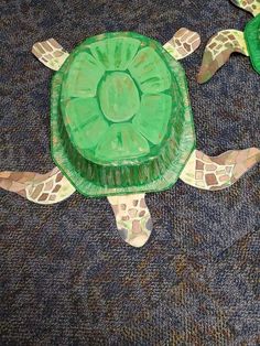 a turtle made out of plastic sitting on the ground